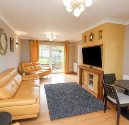 A living room with leather sofas a wall-mounted television and a dining table at 315 Filey Road in Scarborough