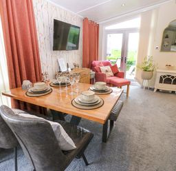 A dining room with a table set for a meal at Plot 32 High Hesket near Armathwaite