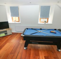 A game room with a pool table and a television on a stand at Dalton Cottage in Llansaint