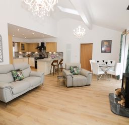 A living room with a sofa and dining area at The Barn in Astwood Bank