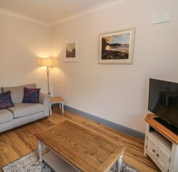 A living room with a sofa and a television at No 1 Lodge Wood, Kenmare, County Kerry
