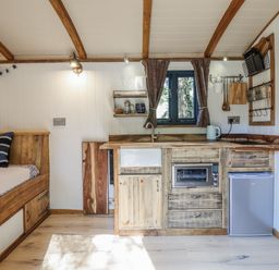 A kitchen with a sink and cabinets at Tanglewood Shepherds Hut in Welshpool