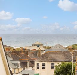 Rooftops of houses with a view of the sea and sky at Cobblestone Cottage in Bude