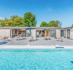 An outdoor area with a swimming pool and seating at Chalet 7 at Landscove Holiday Park Brixham