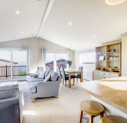 A living room with a dining table and view at Lodge 73 at Riviera Bay Coastal Retreat Brixham