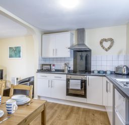 A kitchen with a table and chairs at Chalet 11 at Landscove Holiday Park Brixham