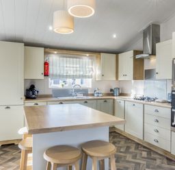 A kitchen with a stove and sink at Lodge 9 at Landscove Holiday Park Brixham