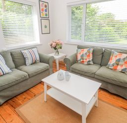 A living room with sofas, a coffee table and a vase of flowers at Bod A Quinte, Carbis Bay
