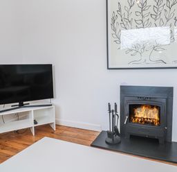 A living room with a fireplace and television at Bod A Quinte in Carbis Bay