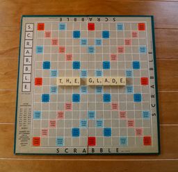 A Scrabble board with the word THE GLADE spelled out on wooden tiles on a wooden floor at 3 The Glade in St Minver Rock