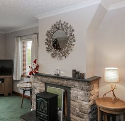 A living room with a television and fireplace at 1 Gilpin House Levens