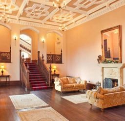 A sitting room with sofas fireplace and staircase at The Hall in Belford