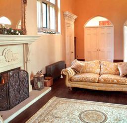 A living room with a sofa a fireplace and a rug at The Hall in Belford