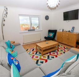 A living room with a sofa and coffee table at 15 Lawnswood Saundersfoot