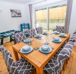 A dining room with a table set for dinner at 15 Lawnswood Saundersfoot