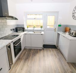 A kitchen featuring cabinets, a sink, stove, and appliances at 15 Lawnswood in Saundersfoot