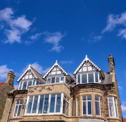 A stone building with three gabled windows under a blue sky at Ocean View in Alnmouth