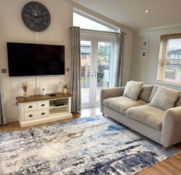 A living room with a television and sofa at Lodge 18 - The Pines Runswick Bay