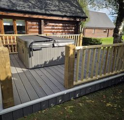 An outdoor area with a hot tub on a deck at Willow in Dolton