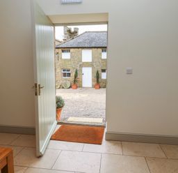 An entrance hall with a door leading to a courtyard at Cragg Lodge in West Woodburn