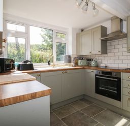 A kitchen with cabinets, oven, and sink at Tan Y Merddyn near Ceunant near Llanrug