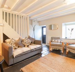 A living room with a sofa and two armchairs with patterned covers and cushions at Ty Dyffryn in Llan Ffestiniog