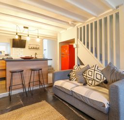 A kitchen and living area with a grey sofa and a red refrigerator at Ty Dyffryn in Llan Ffestiniog