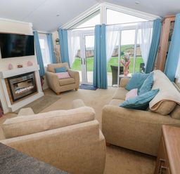 A living room with sofa and armchairs at Gentle Tide Hasguard Cross near Little Haven