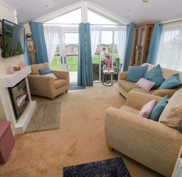 A living room with a television and a fireplace at Gentle Tide Hasguard Cross near Little Haven