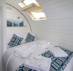 A bedroom with a bed towels and pillows under a skylight at Moel Famau in Bryniau Clwyd near Denbigh