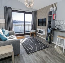 A living room with a sofa and television at Estuary Escape in Porthmadog
