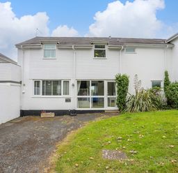 The front exterior of a two story white house with a driveway and lawn at Mor Glas in Abersoch