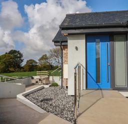 An entrance with a blue door and patio furniture at Lake View in Kestle Mill near Quintrell Downs