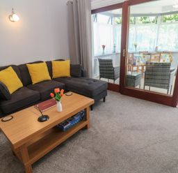 A living room with a sofa and a coffee table at Lake View, Swanpool, Nr Falmouth