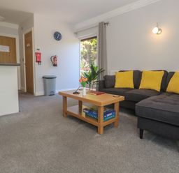 A living room with a table and sofa at Lake View, Swanpool, Nr Falmouth