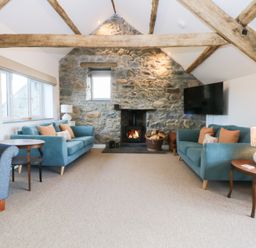 A living room with sofas and a fireplace at Yr Hen Felin in Dyffryn Ardudwy