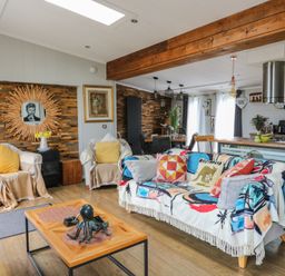 A living room with a sofa and coffee table at Coogee View in Maenygroes near New Quay