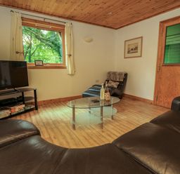 A living room with a large window a glass coffee table a leather sofa a leather armchair and a flat screen tv at Lodge 58 - Oak Tree Lodge Finlakes Holiday Park near Chudleigh
