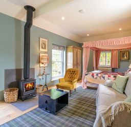 A living room with a stove and sofa at Clock Tower in Stowmarket