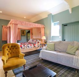 A bedroom with a bed and sofa at Clock Tower in Stowmarket