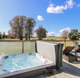 An outdoor area with a hot tub and seating at Angel Lodge - No 27 near Bury St Edmunds