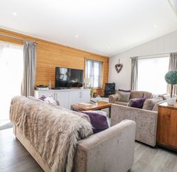 A living room with a television, sofas and a wooden table at Angel Lodge - No 27 near Bury St Edmunds