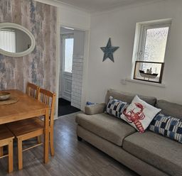 A living room with a dining table and sofa at Seahorses