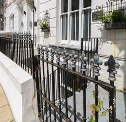 Black metal railing in front of white building with flower boxes on windows at Flat 1 - Sandbanks in Bournemouth