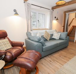 A living room with a sofa and armchair at Y Stabl in Cerrigydrudion