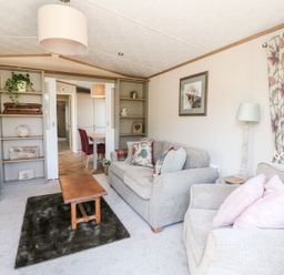 A living room with two armchairs a sofa coffee table and built in shelves at Saorsa in St Fillans