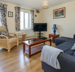 A living room with a sofa armchair coffee table and television at 74 Reap Lane in Southwell near Weston