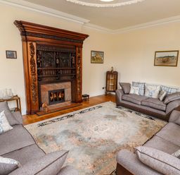 A living room with three sofas and a fireplace at North Wing Middleton Hall Estate near Belford