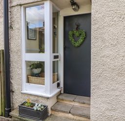 A gray front door with a heart-shaped wreath and a window with a basket inside at Belmont House in Bowness-On-Windermere
