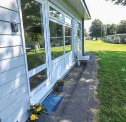 Exterior view of a building with a bench flower pots and a grassy lawn at 61 Norton Park in Dartmouth